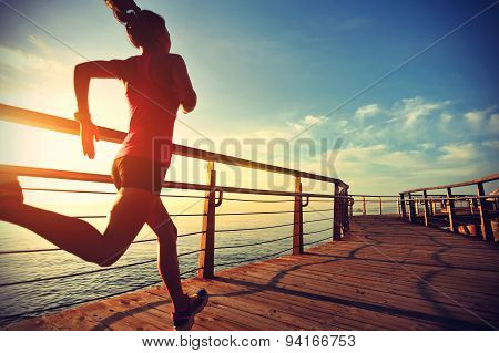 healthy lifestyle sports woman running on wooden boardwalk sunrise seaside