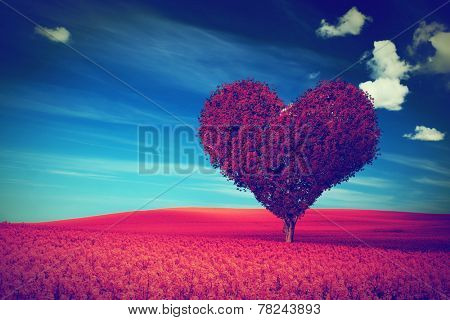 Heart shape tree with red leaves on red flower field. Love symbol, concept for Valentine's Day, wedding etc. Vintage style