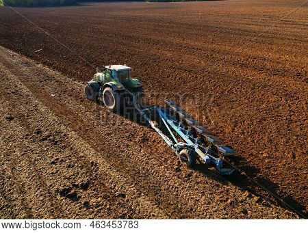 Tractor With Cultivator Plowing Field. Tractor Disk Harrow On Ploughing A Soil. Sowing Seed On Plowe