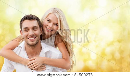 summer holiday, vacation, dating and love concept - happy couple having fun over yellow lights background