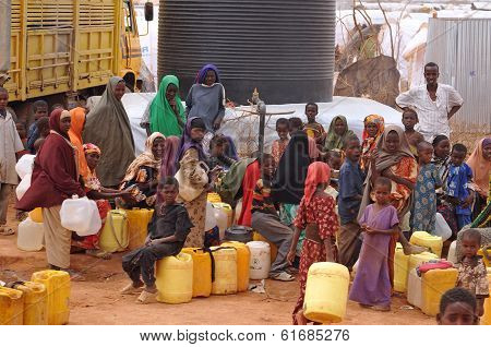 People Waiting To Fill Water And Mess