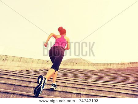 Runner athlete running on stairs. woman fitness jogging workout wellness concept.