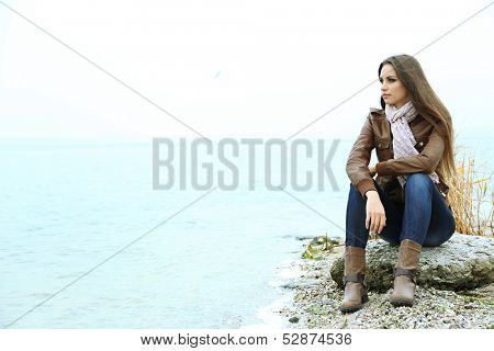 Portrait of young serious woman near river