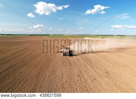 Tractor With Plough On Plowed. Ploughing And Soil Tillage. Agricultural Tractor On Cultivation Field