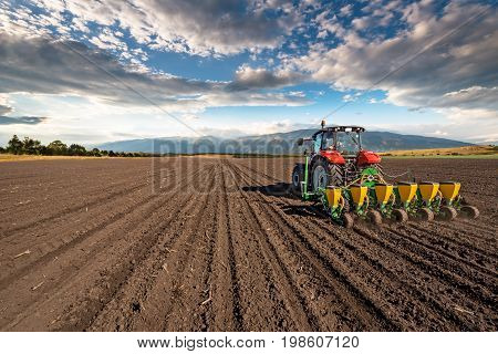 Varna, Bulagria - April 01, 2017. Big Steyr tractor with attached Great Plains seeder for sunflower seeds. Agriculture tractor sowing seeds and cultivating field.