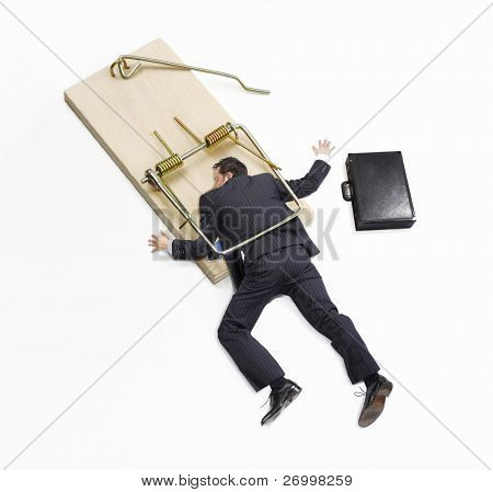 Businessman trapped on mousetrap on white background.