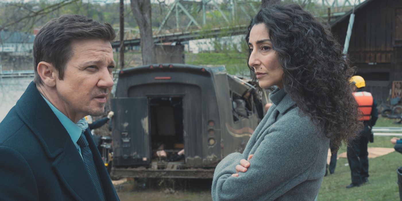 Evelyn (Necar Zadegan) looks at Mike (Jeremy Renner) with burned bus behind in Mayor of Kingstown