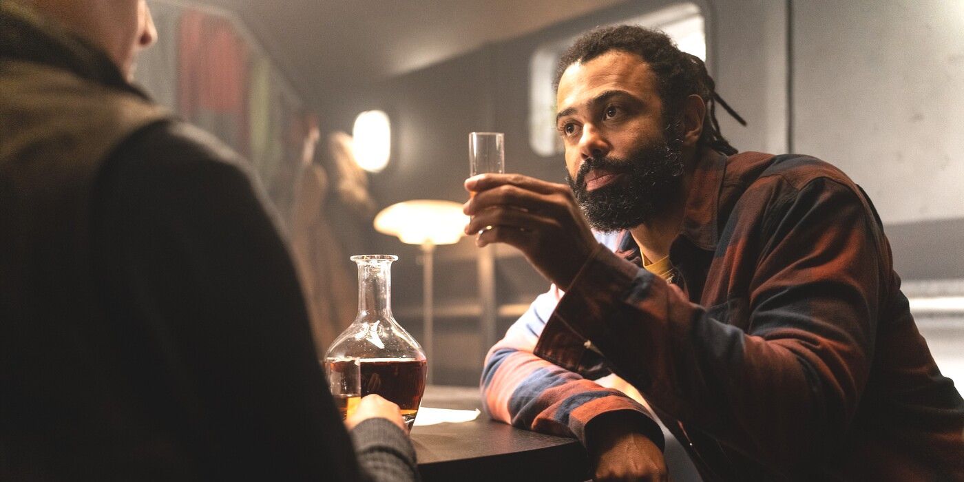 Andre Layton (actor Daveed Diggs) raises a glass at a table in Snowpiercer Season 4