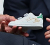 L'ex-tennisman Stan Smith lui avait offert une paire dédicacée de ses célèbres baskets.
L'ex-champion de tennis Stan Smith offre une paire de baskets dédicacées à Kate Middleton pour son fils le prince Louis, au tournoi de Wimbledon, le 14 juillet 2019.