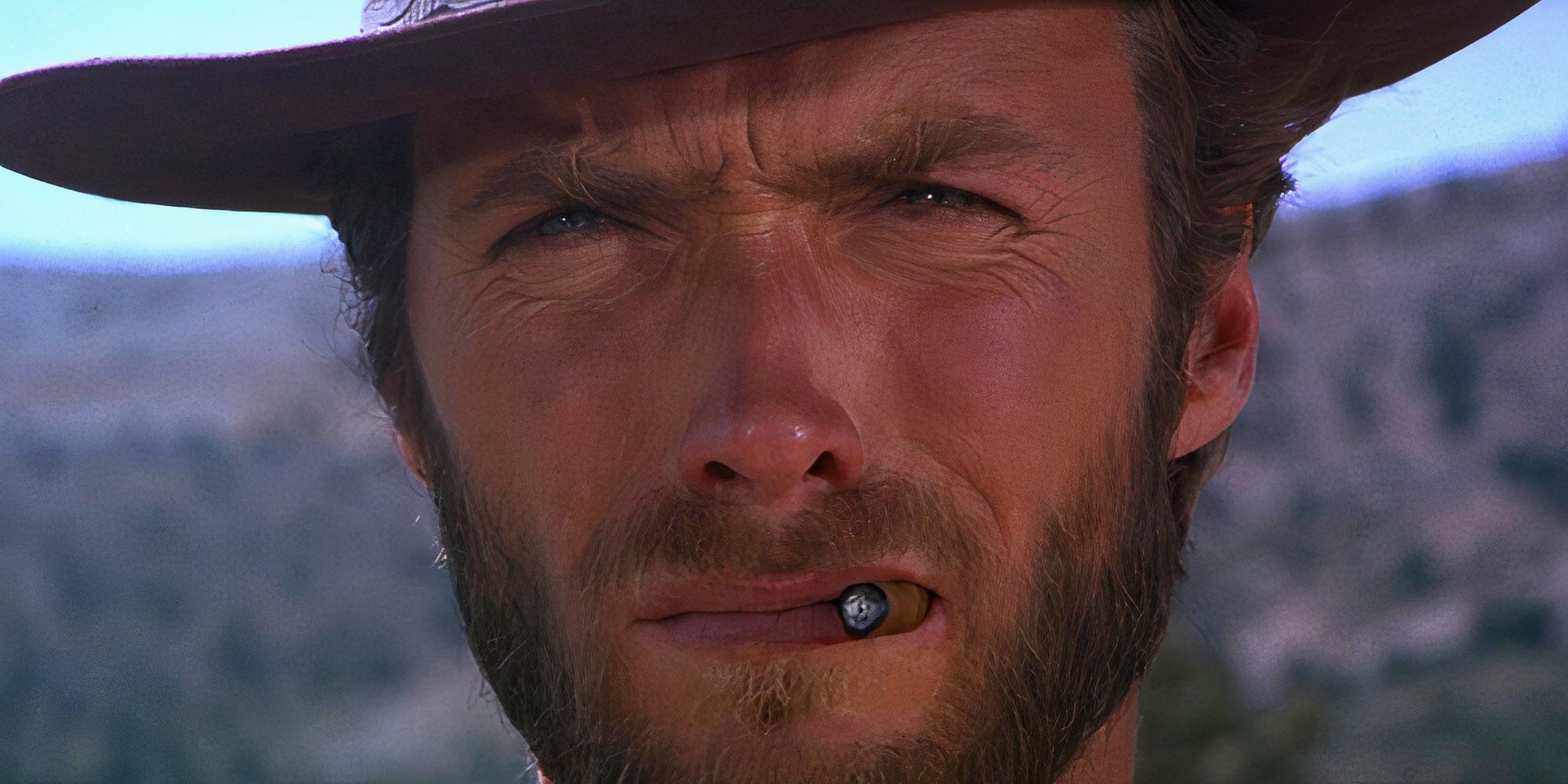 Clint Eastwood squinting under a cowboy hat with a cigar in the corner of his mouth in The Good the Bad and the Ugly