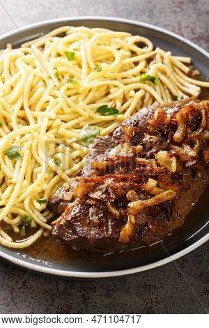 Traditional Dry Aged Roast Beef With Fried Onion Rings And Swabian Spaetzle Closeup On The Plate On 