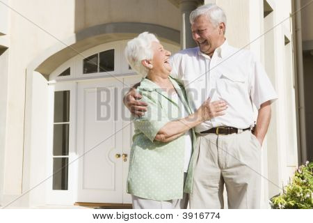 Senior Couple Standing Outside Their Home