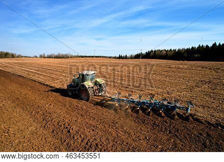 Tractor With Cultivator Plowing Field. Tractor Disk Harrow On Ploughing A Soil. Sowing Seed On Plowe