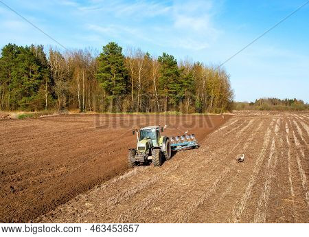 Tractor With Cultivator Plowing Field. Tractor Disk Harrow On Ploughing A Soil. Sowing Seed On Plowe