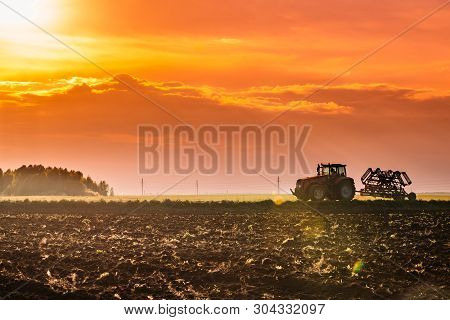 Tractor On Road In Spring Season. Beginning Of Agricultural Spring Season. Cultivator Pulled By A Tr