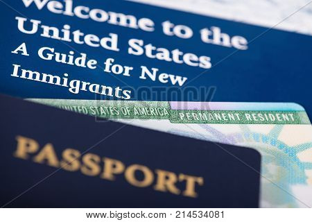 United States of America permanent resident card green card displayed with a passport. Immigration concept. Close up with shallow depth of field.