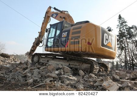 MILOVICE, CZECH REPUBLIC - FEBRUARY 25, 2014: Demolition excavator destroys abandoned buildings in the area of the former Soviet military base in Milovice, some 40 km from Prague, Czech Republic.