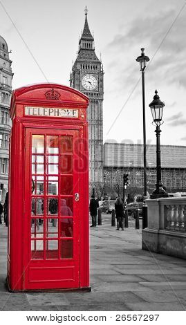 A  traditional red phone booth in London with the Big Ben in a black and white background