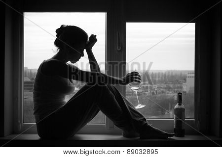 Woman In Depressed Mood Sits On The Window