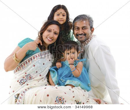 Happy Indian family with two children in traditional costume sitting on white background