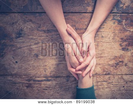 Man And Woman Holding Hands At A Table