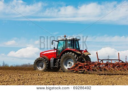 Farmer Plowing The Field. Cultivating Tractor In The Field. Red Farm Tractor With A Plow In A Farm F