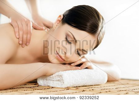 Young and healthy woman in spa salon. Traditional Swedish massage therapy and beauty treatments. 