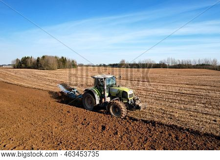 Tractor With Cultivator Plowing Field. Tractor Disk Harrow On Ploughing A Soil. Sowing Seed On Plowe