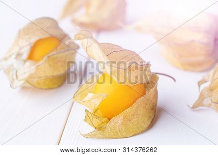 Physalis Fruit (physalis Peruviana) On A White Wooden Background Close-up. Cape Gooseberry.  Minimal