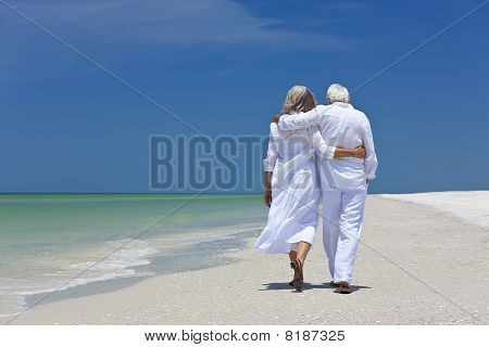 Vista posterior de pareja Senior caminar solo en una playa Tropical