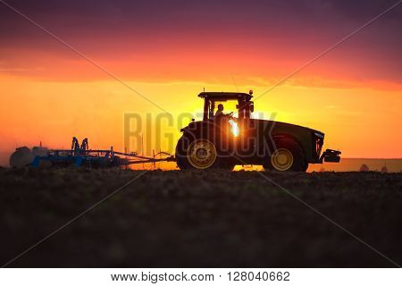 Farmer In Tractor Preparing Land With Seedbed Cultivator