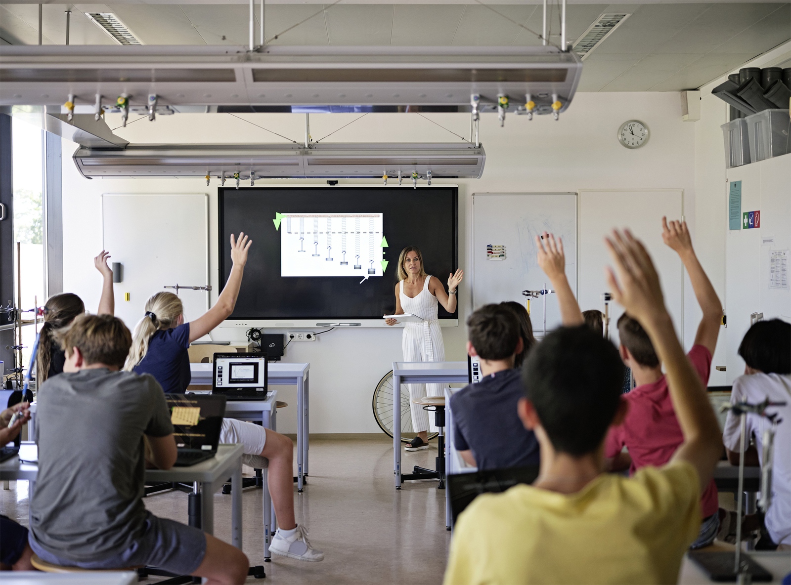 Kinder melden sich in einem Klassenraum