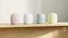 Four Nest Wifi Pros lined up on top of a desk in four different colors: Linen, Snow, Fog and Lemongrass