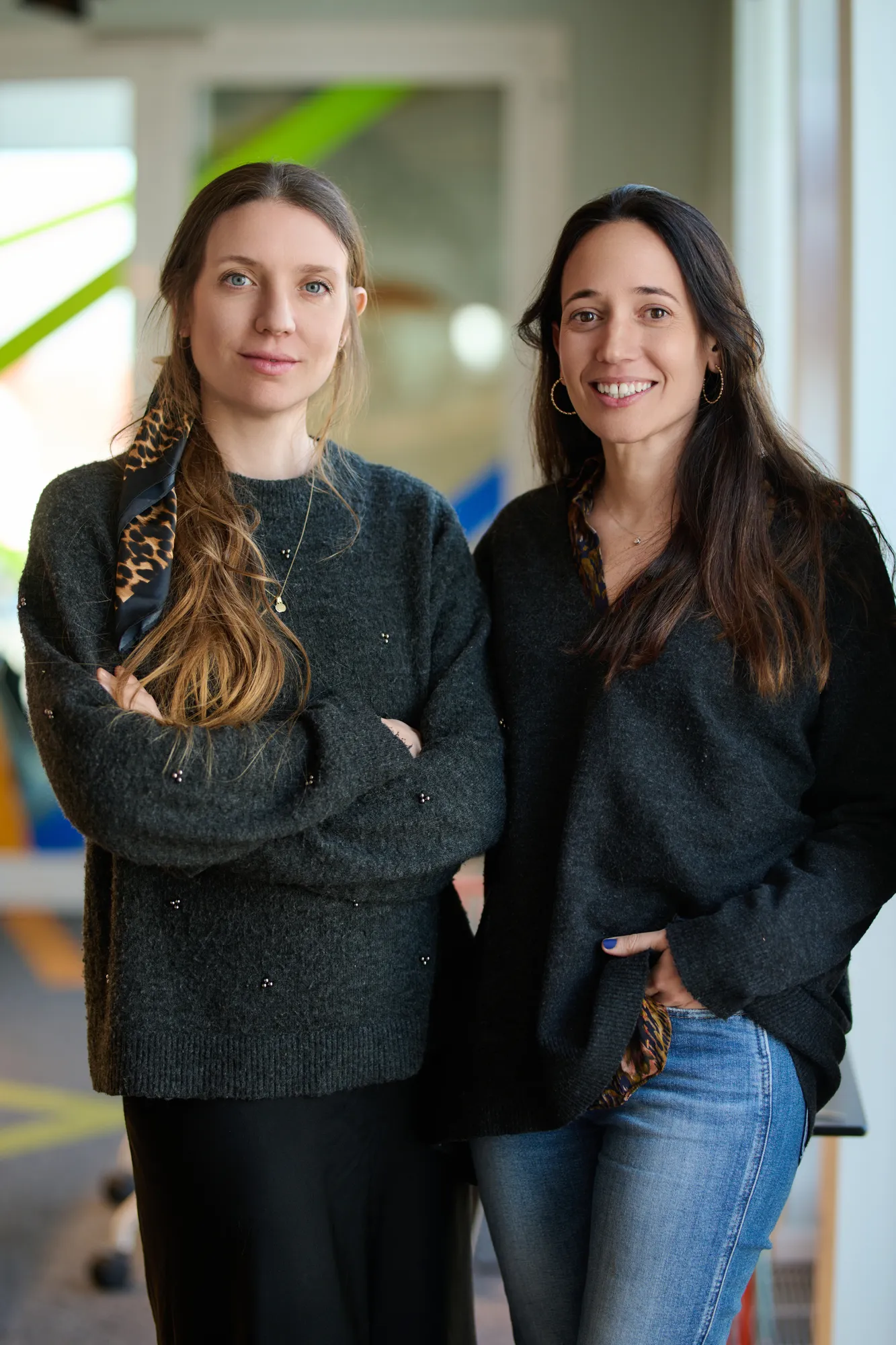 Two women stand looking at the camera