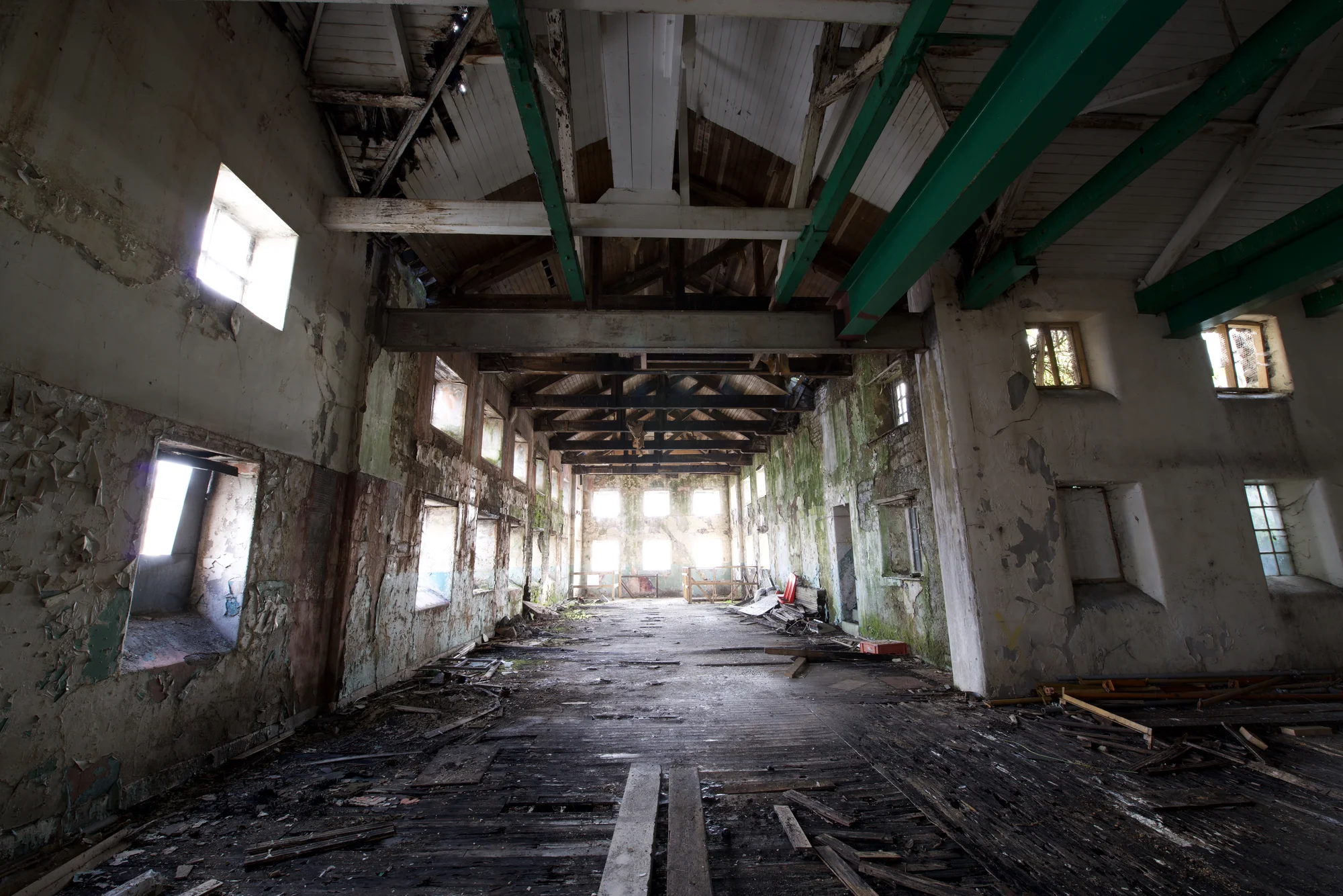 An old, empty building where you can see the original character of the building's stonework, exposed original timber and steel beams/