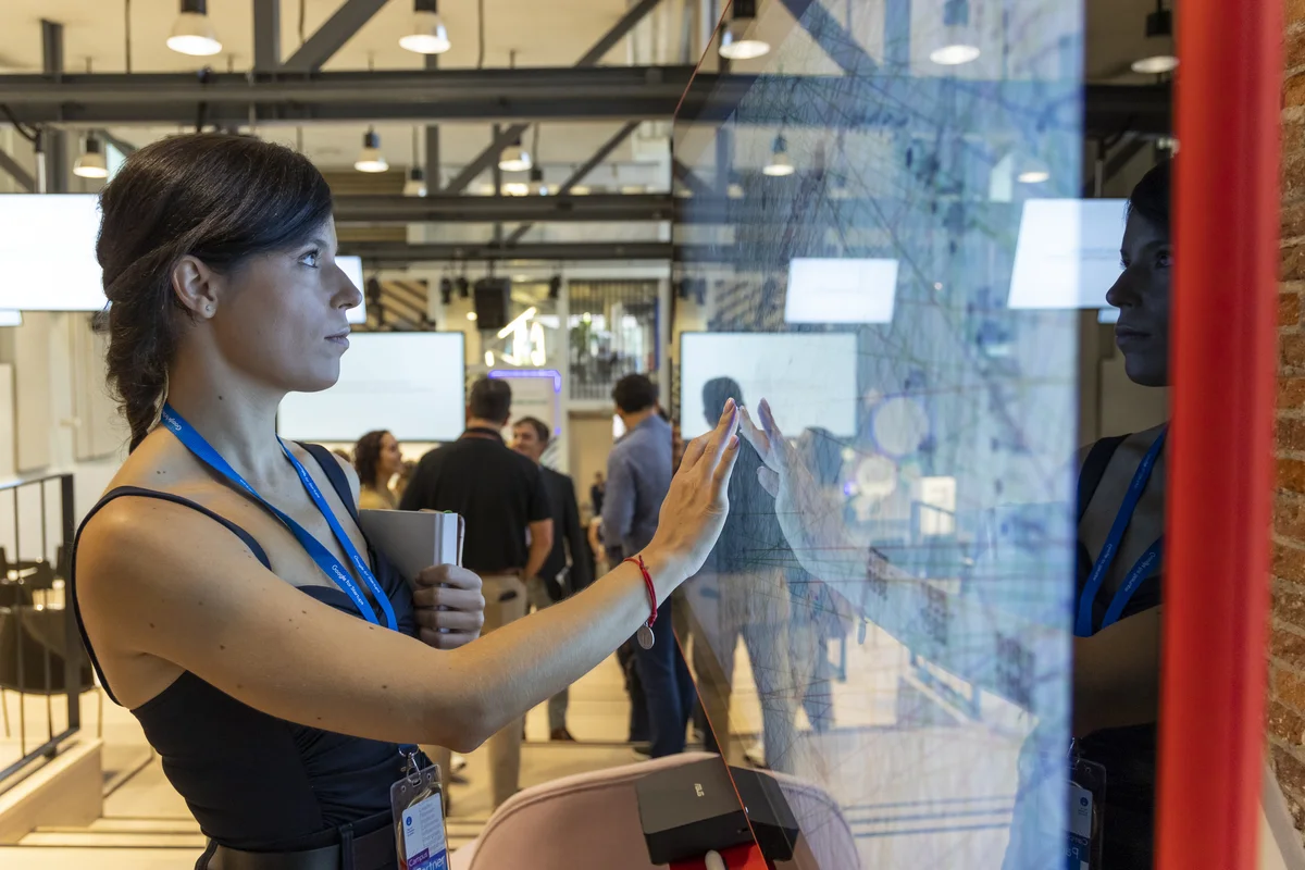 Program image photo: A woman reviewing an interactive map on a screen during an event.