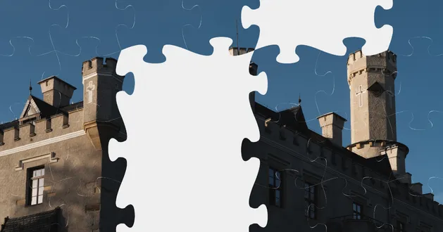 A picture of a puzzle being put together. We can see blue sky and a castle in the center of the puzzle. There are a few blank spots where the puzzles are missing, but we can already see 3 turrets of the castle and one small window. It’s Karpniki Castle.