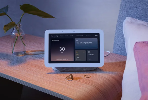 Image showing a Nest Hub on a bedside table with the Your Evening page on the screen.