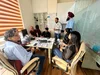 A group of people having a meeting around a desk in a room