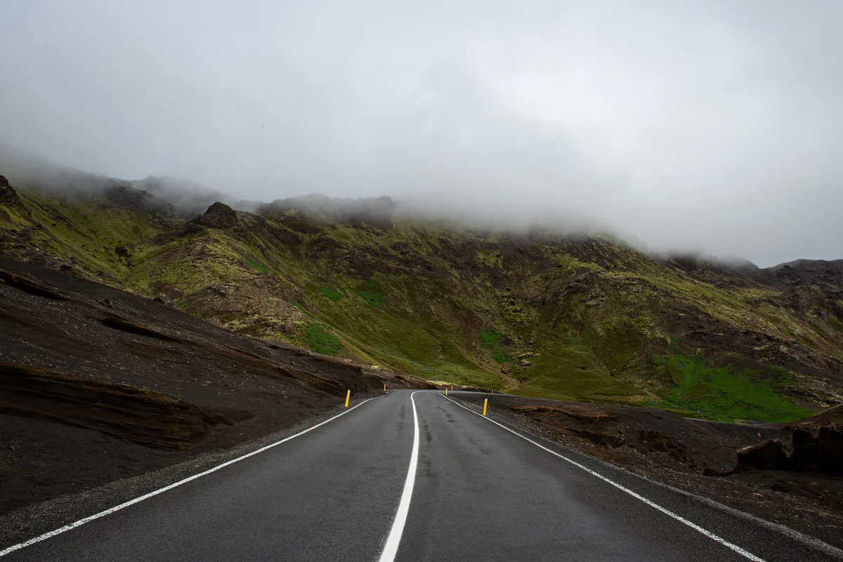 photo of open road with grassy hills