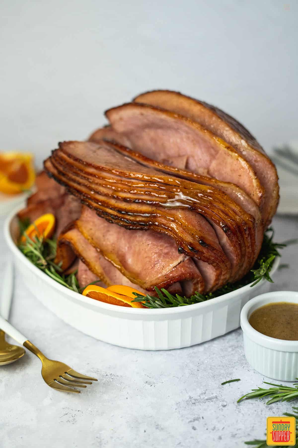 honey glazed ham in a white casserole dish