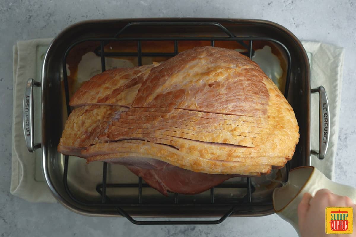 adding stock to the baking dish