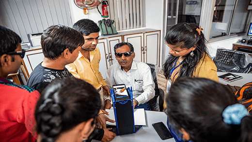 Un instructor muestra cómo usar la tecnología de apoyo para leer braille en un centro de enseñanza para personas ciegas en India. 