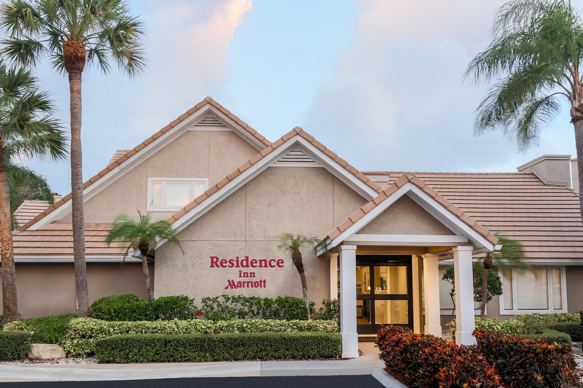 a building with palm trees and a sign