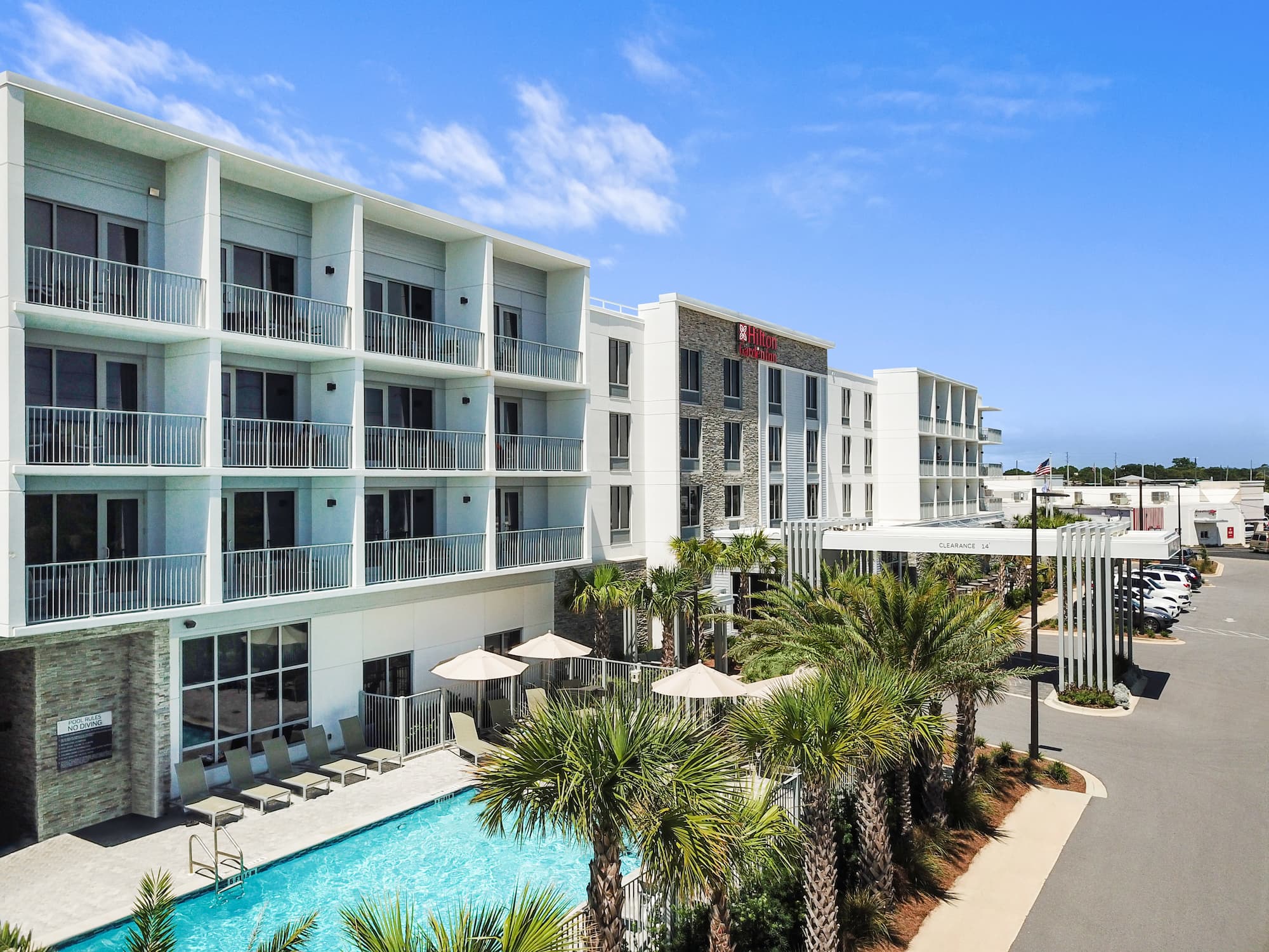 a building with a pool and palm trees