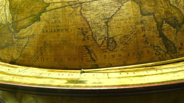 The map of India on a round globe. The big round brown globe showing maps of different continent