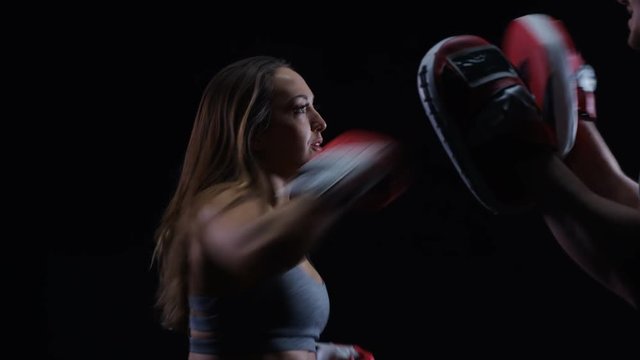  Fit young woman doing boxing training with male trainer.