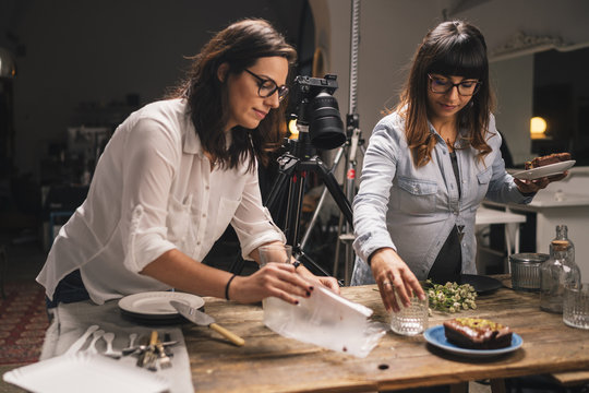 Pregnant woman with a colleague working on a food photo shoot