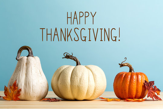 Thanksgiving message with pumpkins on a blue background