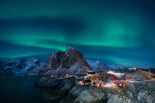 Fisherman village with Aurora in the background travel concept world explore northern light / Lofoten Norway